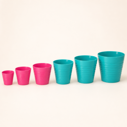 A lineup of six ribbed planters in graduating sizes, ranging from pink to turquoise.