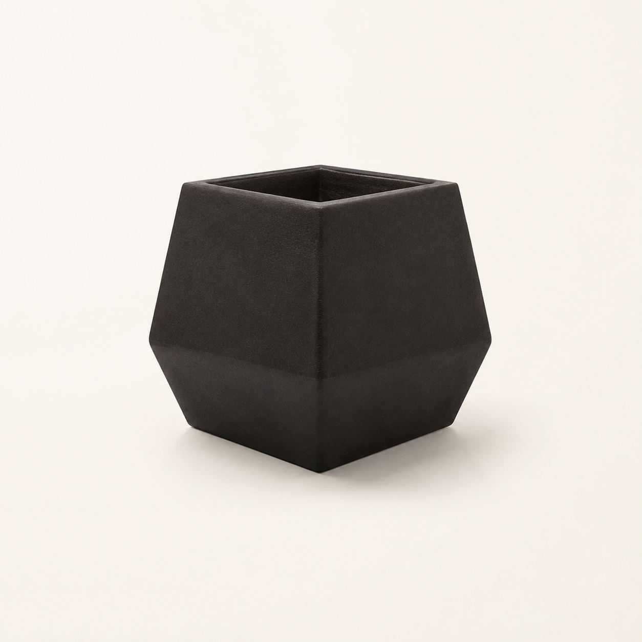 Dark geometric faceted Diamond Planter on a light background.