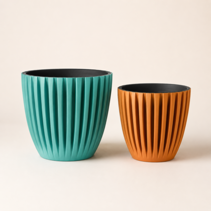 Two fluted Orio Planters in teal and orange displayed side by side against a neutral background.