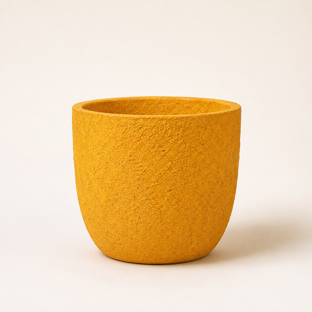 Yellow rock planter with a textured finish against a light background.