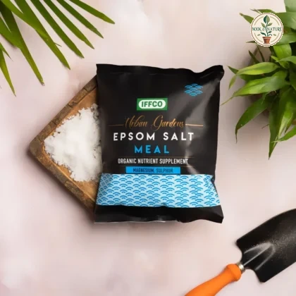 IFFCO Urban Gardens Epsom Salt Meal pouch with loose white crystals on a wooden tray and a garden trowel.