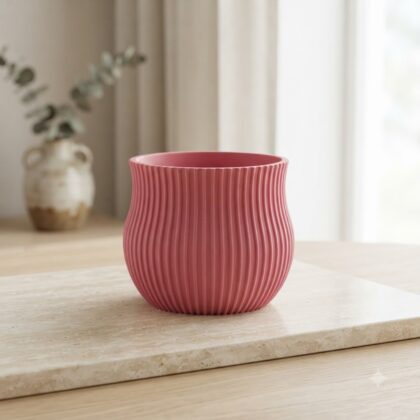 Pink fluted Crown decorative pot on a stone surface indoors.