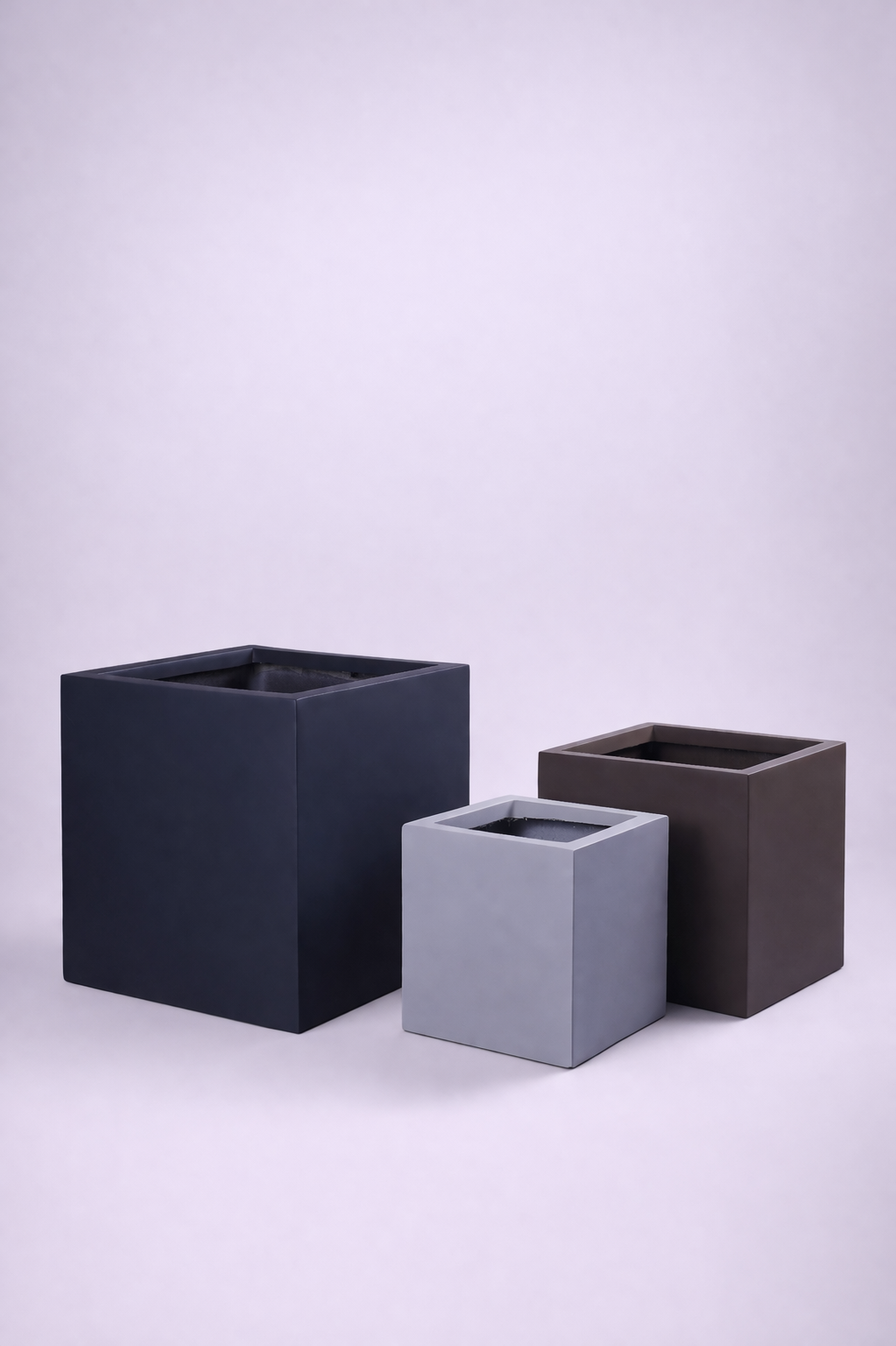 Three square cube planters in different sizes and shades against a neutral background.